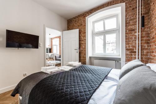 Un dormitorio con una cama grande con una pared de ladrillo. en Apartament SWEET TIME, en Wroclaw