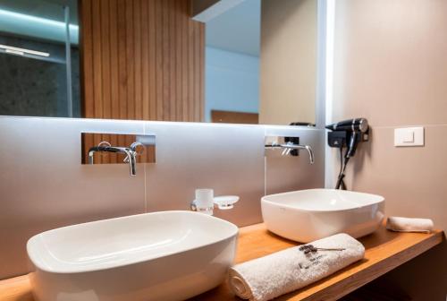 a bathroom with a sink and a large mirror at Messinian Icon Hotel & Suites in Kalamata