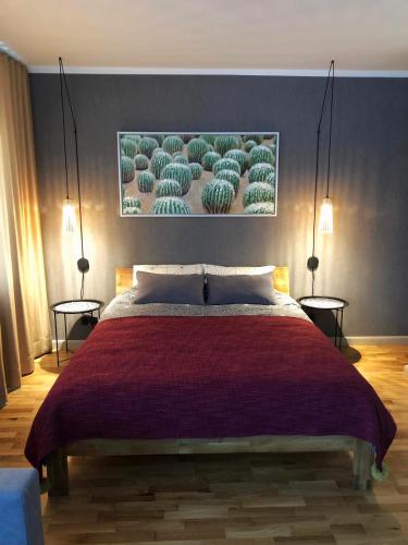 a bedroom with a large bed with two side tables at Kaktuss apartamenti Smiltene in Smiltene