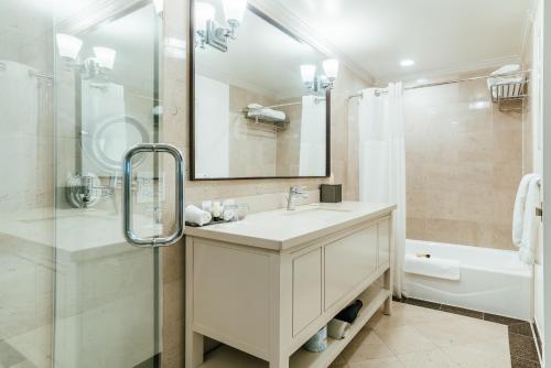 a white bathroom with a sink and a shower at Warwick Denver in Denver