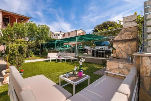 un pequeño patio con muebles de exterior y césped en Apartments Lovric en Pula