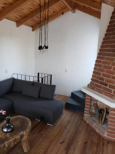 a living room with a couch and a fireplace at Cabaña Eucalipto 32 in Mazamitla