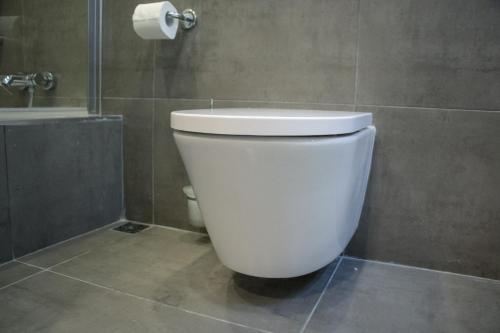 a white toilet in a bathroom with a shower at Sunshine Suites in Birkirkara