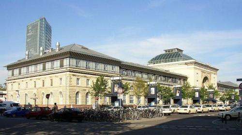 a large building with cars parked in a parking lot at Central Hotel in Mannheim