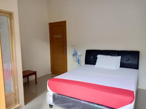 a bedroom with a bed with a red and white blanket at Rosalina Homestay in Rantepao