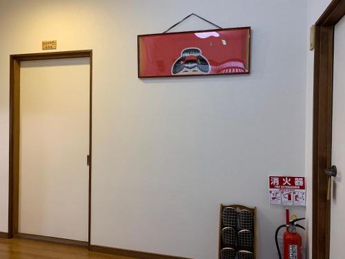 una puerta con una foto de un coche en la pared en KIX House 和楽二号館, en Izumisano