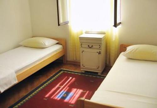 a small bedroom with two beds and a dresser at Holiday home Jaroje- 80m from beach in Pa&scaron;man
