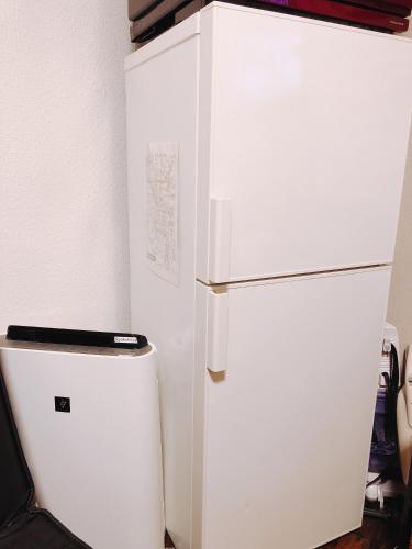a white refrigerator sitting next to a small freezer at Ryokoheya Awajikan in Osaka