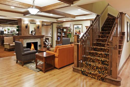 a living room with a staircase and a fireplace at Country Inn & Suites by Radisson, Texarkana, TX in Texarkana - Texas