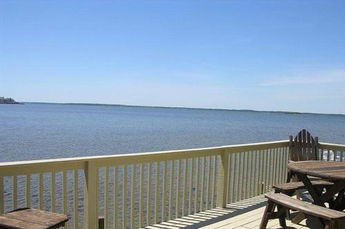 a wooden deck with a picnic table and the water at Montego Bay - South Ocean Drive 203 in Ocean City