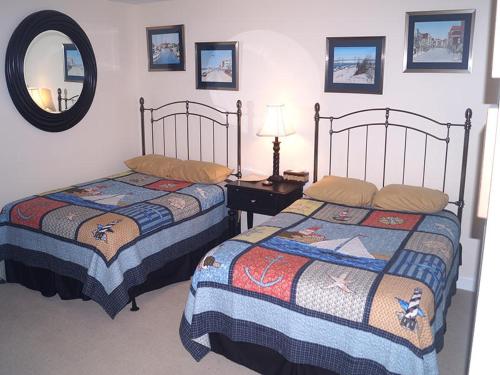 a bedroom with two beds and a table with a mirror at Ocean'S Edge 401 Condo in Ocean City