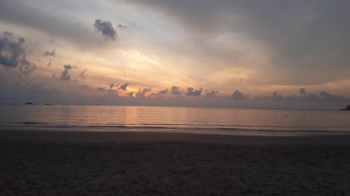 a sunset on a beach with the ocean at juara seaview chalet, kampung juara in Kampong Juara