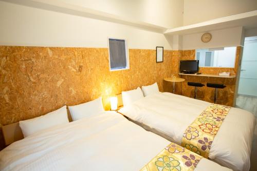 ein Schlafzimmer mit 2 Betten und einem TV in der Unterkunft Rest inn Kyoto in Kyoto