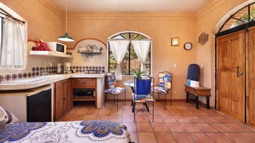 a kitchen with a sink and a table and chairs at Posada del Molino in Todos Santos