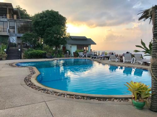 a swimming pool with the ocean in the background at Utopia House Phangan in Mae Haad