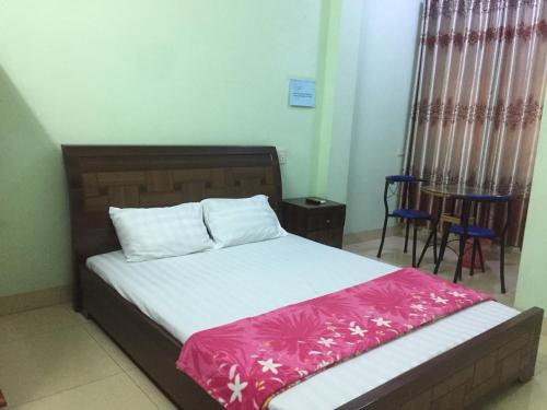 1 dormitorio con 1 cama con manta rosa y blanca en Hân hân en Ha Long