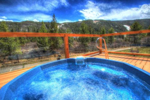 a hot tub on a deck with a view of the mountains at Ffd7 Frostfire Condo in Keystone