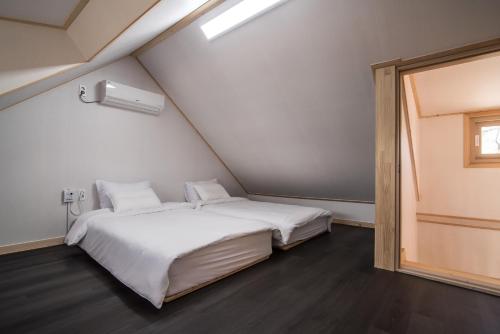 a bedroom with a large white bed and a window at Built in Garage Jeju in Jeju