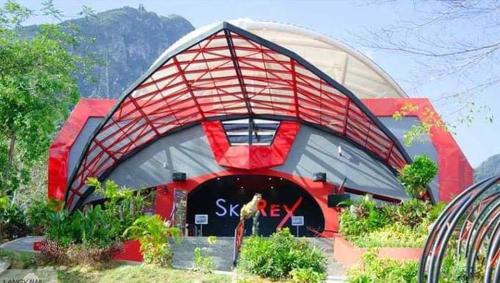 a large red and gray building with a roof at Nu Melati Hotel in Pantai Cenang