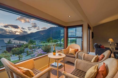 a room with a large window with chairs and a table at London Lane in Queenstown