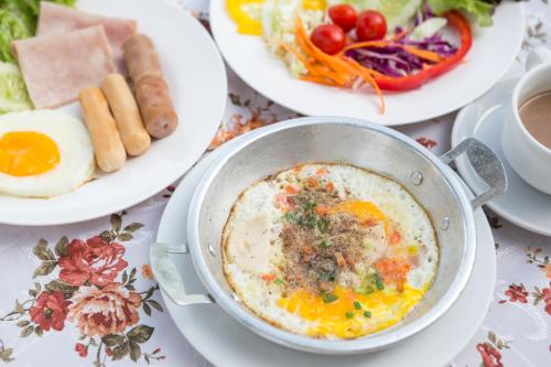 una mesa con un plato de huevos y otros alimentos para el desayuno en Khao Yai Fantasy Resort en Nong Nam Daeng