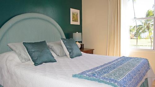 1 dormitorio con cama blanca y almohadas azules en Palm View, en Humacao