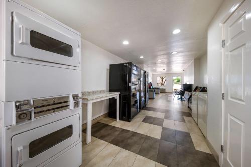 a kitchen with white appliances and a hallway at Motel 6-Dallas, TX - Farmers Branch in Farmers Branch
