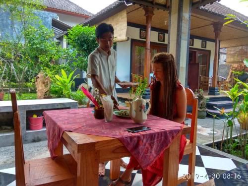 Un garçon et une fille assis à une table dans l'établissement Milla Homestay, à Sidemen