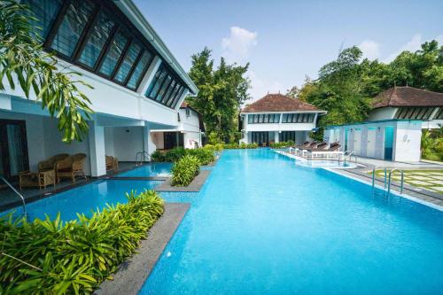 a swimming pool in front of a building at Nihara Resort and Spa Cochin in Cochin