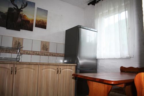a kitchen with a stainless steel refrigerator and a wooden table at Domek Tosia in Bukowiec