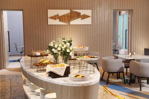 a table with plates of food on it in a room at Capri by Fraser Johor Bahru in Johor Bahru