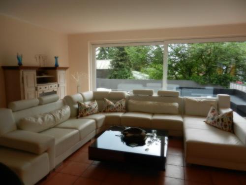 a living room with a couch and a large window at Hotel Am Sportpark in Duisburg