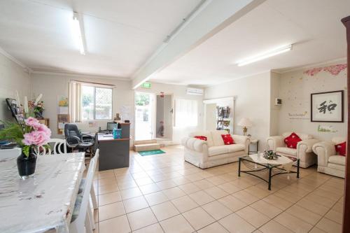 a living room with two couches and a table at Pure Land Guest House in Toowoomba