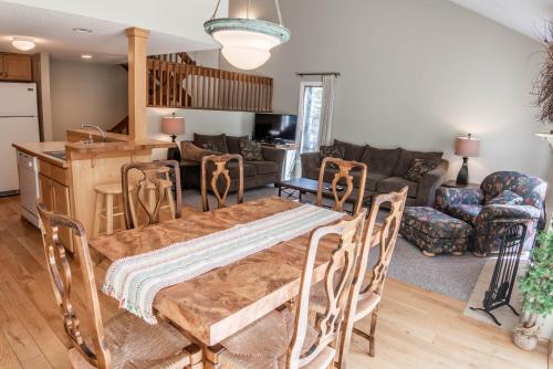 a kitchen and living room with a table and chairs at Secluded Harbor Springs Condo in Harbor Springs