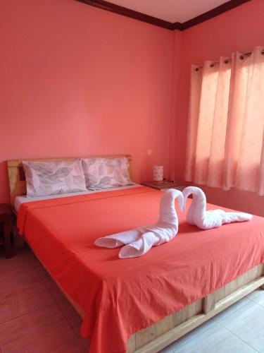 two swans sitting on a bed in a bedroom at Stella'z guesthouse in Siquijor