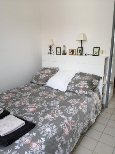 a bedroom with a bed with a gray and white blanket at Tee 4 in Nîmes