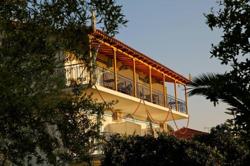 a building with a balcony on top of it at Elena's Family Apartments in Leonidion