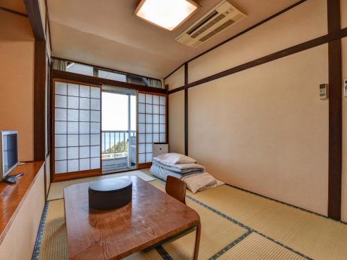 a room with a table and a bed and a window at Eboshiso in Tamagawa