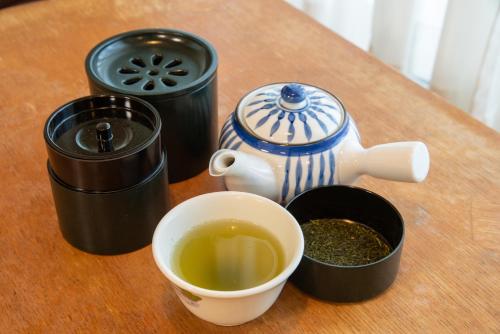 a cup of tea and a teapot on a table at Eboshiso in Tamagawa