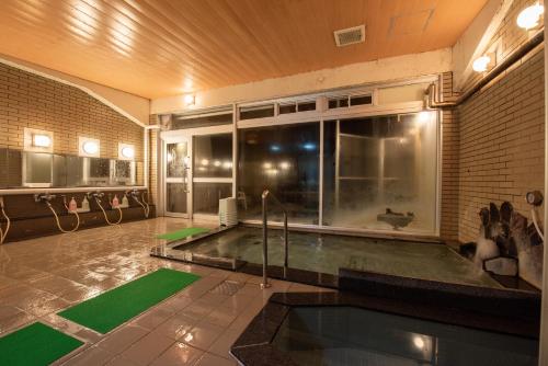 a swimming pool in a room with a large window at Eboshiso in Tamagawa