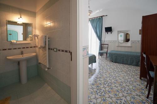 ein Bad mit einem Waschbecken und einem Spiegel in der Unterkunft Hotel L'Argine Fiorito in Atrani