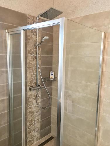 une douche avec une porte vitrée dans une salle de bain dans l'établissement Beach house Atlantique 400m de la plage, au Bois-Plage-en-Ré