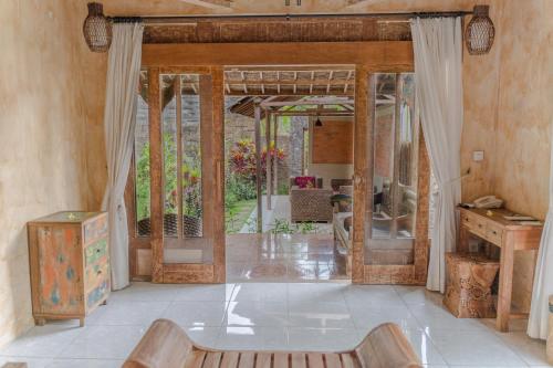 a living room with a table and a mirror at Senetan Villas and Spa Resort in Payangan