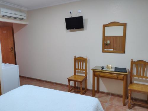 a bedroom with a bed and a desk and a mirror at Hotel La Posada in La Palma