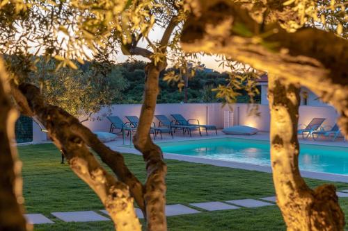 - Vistas a la piscina a través de los árboles en Mangie Villa, en Hersonissos