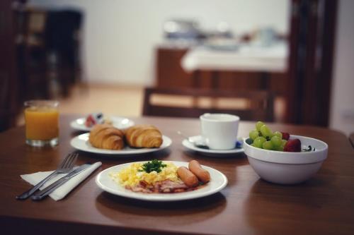 a table with plates of food and a bowl of fruit at Zámecký Penzion in Valašské Meziříčí
