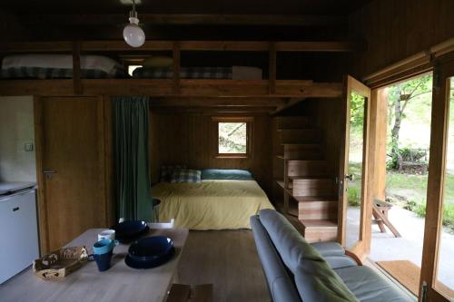 a bedroom with a bed and a couch in a room at Quinta do Castro Wood House in Marco de Canavezes