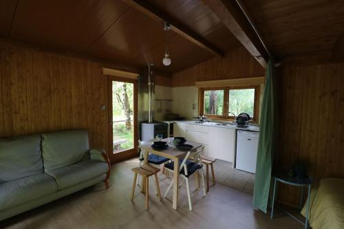a kitchen and living room with a table and a couch at Quinta do Castro Wood House in Marco de Canaveses