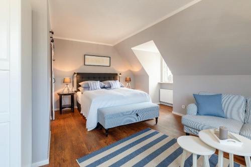 a bedroom with a bed and a couch at Friesen-Lodge Apartments in Breklum