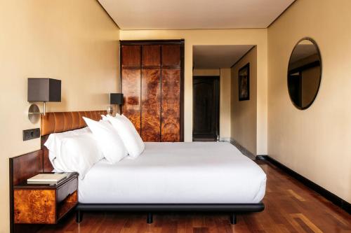 a bedroom with a large white bed and a mirror at Hotel Villa Real, a member of Preferred Hotels & Resorts in Madrid